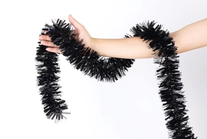 Close-up of metallic black foil tinsel garland with dense fringe for Halloween parties