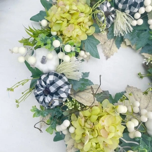 Rustic fall wreath with white pumpkins, cream berries, and faux greenery for home decor