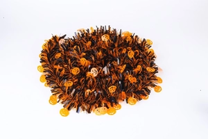Close-up of orange and black Halloween tinsel garland with shiny pumpkin jack-o'-lanterns