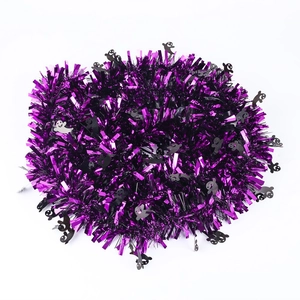 Macro detail of Halloween purple metallic tinsel garland with small black ghost shapes