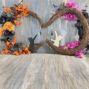 Detail of black hexagonal crystal earrings hanging on a decorative Halloween floral wreath