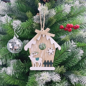 Close-up of Nordic wooden Christmas house ornament with reindeer and snow details