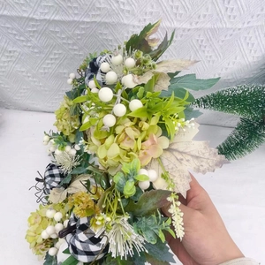 Artificial wreath with white berries, autumn pumpkins and green leaves for home decoration