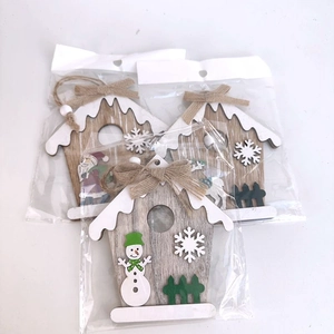Detailed view of three wooden Christmas house ornaments with Santa and Snowman motifs