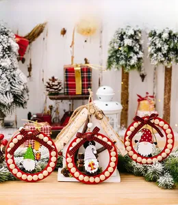 Close-up of wooden Christmas gnome ornaments with red beads and plaid bows on snowy decor