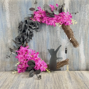 Detail of moon-shaped Halloween wreath featuring black cat silhouette and dark roses