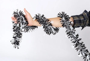 Detail view of Halloween tinsel garland with white ghost ornaments wrapped on arm
