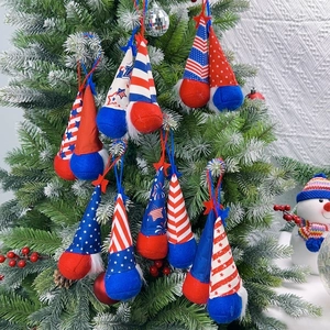 Patriotic July 4th gnome ornaments with stars and stripes hanging on a festive tree