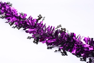Detail of purple foil tinsel garland with black ghost cutouts for Halloween parties