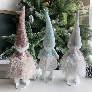 Close-up of pink, blue, and white sequined Christmas Gnomes with soft plush textures