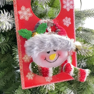 Detail of 3D plush snowman Christmas door handle hanger with festive bell and scarf