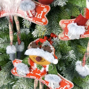 Peluche renne de Noël avec skis en bois suspendue sur une branche décorée