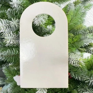 Close-up of a white rectangular door hanger with a circular hole on a green Christmas tree