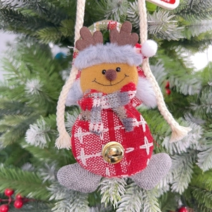 Nahaufnahme eines karierten Rentier-Anhängers mit goldenem Glöckchen am Weihnachtsbaum