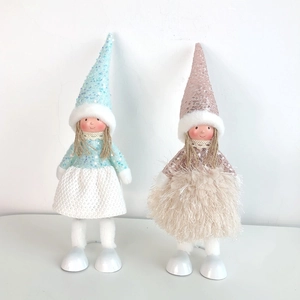 Close-up of sparkling sequin fabrics and plush materials on two Christmas angel dolls
