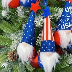 Detail of USA themed Independence Day plush gnomes with stars and stripes hanging on a tree