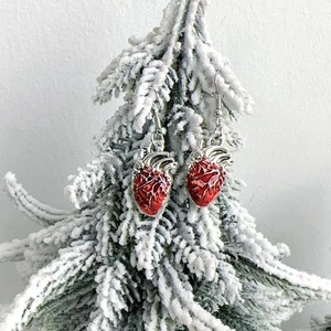 Détail des boucles d'oreilles cœur anatomique en émail rouge sur branche enneigée