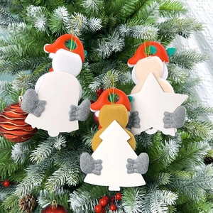 Close-up of felt Christmas tree ornaments with white message boards on snowy branches
