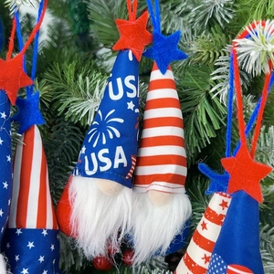 Patriotic Independence Day gnome plush ornament hanging on a pine tree with USA star patterns