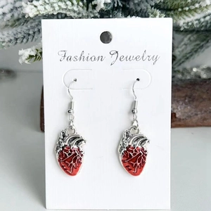 Gros plan de boucles d'oreilles cœur anatomique en émail rouge et métal argenté
