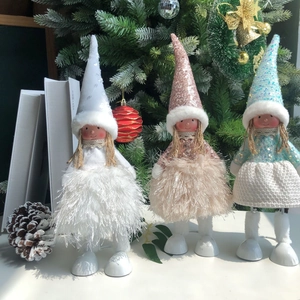 Detailed close-up of three Christmas angel dolls in white, pink, and blue sequin outfits