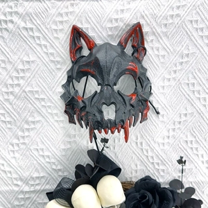Dettaglio di una spaventosa maschera da lupo nero con schizzi di sangue rosso per Halloween
