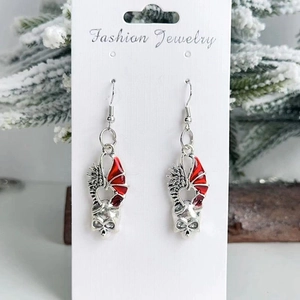 Détail de boucles d'oreilles gothiques tête de mort avec ailes de dragon rouges
