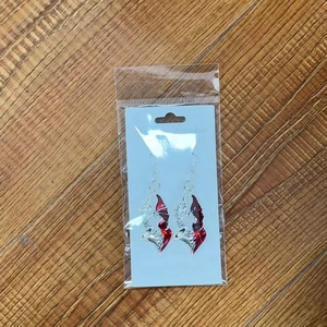 Détail de boucles d'oreilles Halloween avec ailes du diable rouges et un cœur