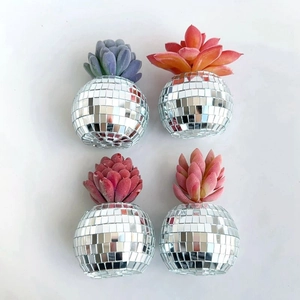 Macro view of disco ball planters featuring colorful faux succulents on white background