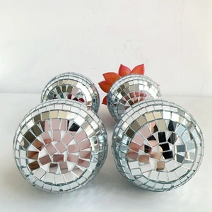 Detailed view of disco ball planters with mirrored glass tiles and red succulent plant