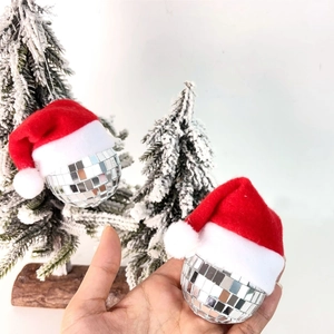 Close-up of silver mini disco ball ornaments with red Santa hats for Christmas trees