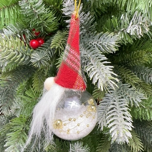 Close-up of a Christmas gnome ornament with red plaid hat hanging on a tree