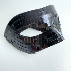 Macro detail of hand-crafted disco ball half mask with black reflective mirror tiles