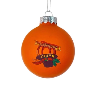 Close-up of orange Thanksgiving ornament ball with Happy Thanksgiving print and pumpkin