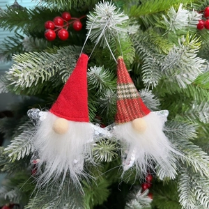 Detail of hanging gnome Christmas ornaments with silver sequin stars on a tree
