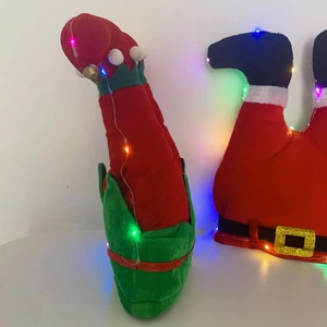 Dettaglio di gambe di elfo in peluche e Babbo Natale con lucine LED colorate scintillanti
