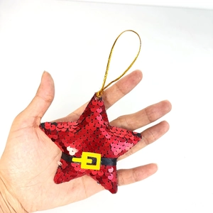 Close-up of red sequined star ornament featuring Santa belt detail and golden hanger