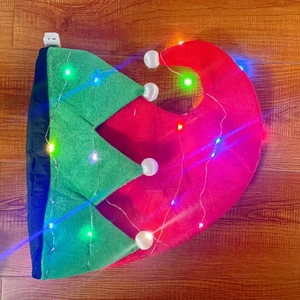 Dettaglio cappello da elfo rosso e verde con luci LED integrate e scatola della batteria