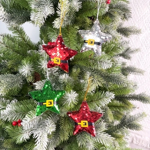 Sparkly star Christmas tree ornaments with Santa belt detail on festive pine branches