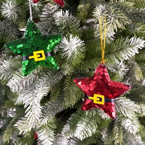 Close-up of star ornaments with sequins and Santa belt hanging on a Christmas tree