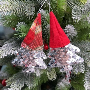 Close-up of sequined gnome tree ornaments with pointed hats hanging on a Christmas tree