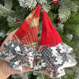Close-up of sequined Christmas tree gnome ornaments with red and checkered hats