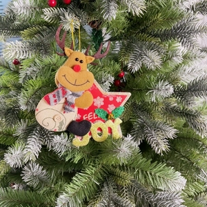 Close-up of a festive Christmas ornament featuring a reindeer and snowman on a snowy tree