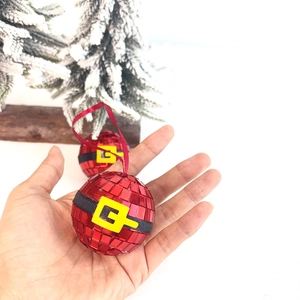 Close-up of red mosaic disco ball ornament with Santa belt detail and red ribbon