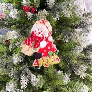 Christmas snowman ornament with Noel letters and red plaid hat hanging on a pine tree