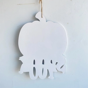 Close-up of a white pumpkin hanging sign with cutout BOO letters for Halloween decor