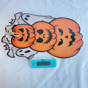 Detailed view of the Halloween pumpkin hanging sign weighing 59.3g on an electronic scale