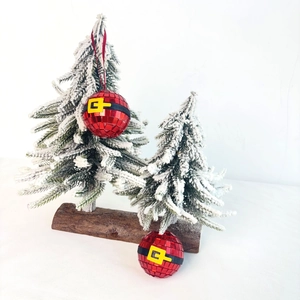 Red Santa Claus disco ball ornaments with mirror tiles hanging on a snowy Christmas tree