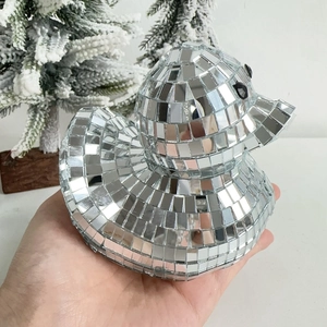 Close-up of a silver disco ball mirror duck figurine with reflective glass mosaic tiles