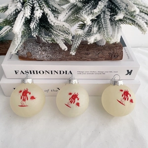 Detail of three cream Halloween balls with red blood splatters and silver metal caps